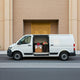 A delivery van with "Petals by Aemi" branding, parked in front of the iconic Burj Khalifa, loaded with elegant floral arrangements ready for delivery.